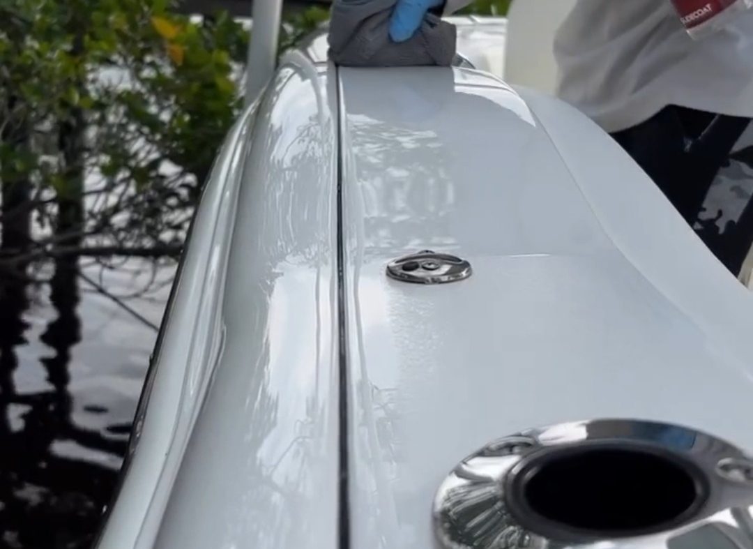 A man is scrubbing the front of a boat, ensuring it is clean and well-maintained.